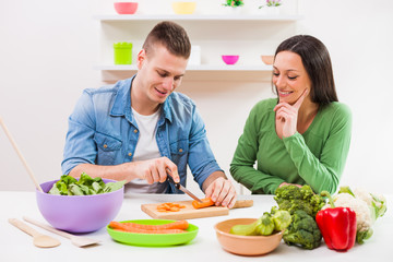 Young couple cooking in their kitchen.