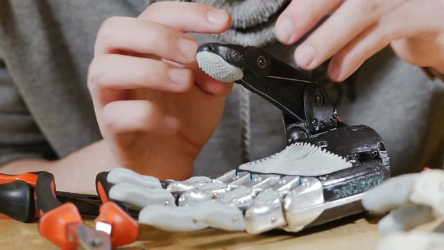 Man builds innovative product - robotic arm printed with 3d Printer. 4K.