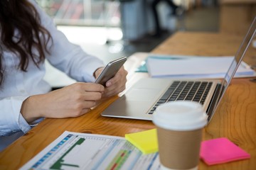Female business executive using mobile phone