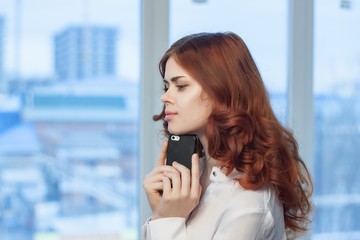 Fototapeta premium a window in the office and a woman with red hair