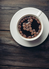 cup with coffee beans on the dishes side view...