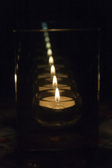 candle in a candlestick with parallel walls which give a lot of reflections