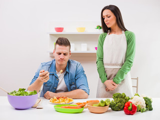 Young couple cooking in their kitchen.