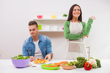 Young couple cooking in their kitchen.