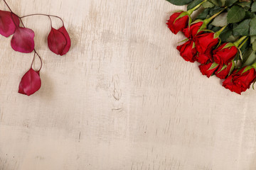 Red roses on wood vintage background. Concept for romantic love design. Fresh natural flowers. Wooden grunge board.