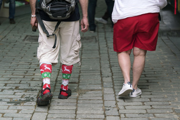 Fototapeta na wymiar Man and woman in shorts walk on the sidewalk