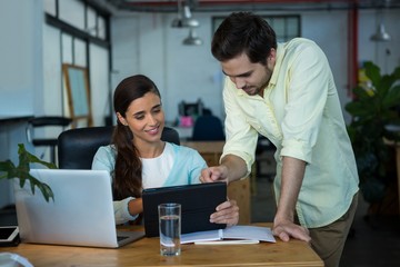 Business executives discussing over digital tablet