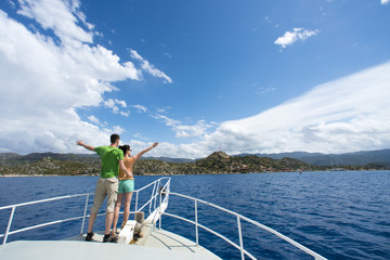 Couple man and woman on the bow of white yachts