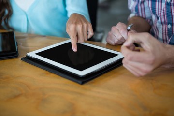 Business executives using digital tablet at desk