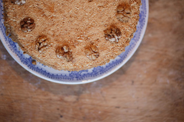 honey cake in blue white plate on light brown wooden background copyspace