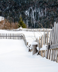 Wooden fences foreground. Winter mountain view at dawn, the sun'