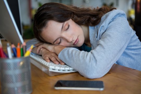 Female Graphic Designer Sleeping At Desk