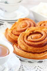 Baked sweet cinnamon rolls with cup of tea