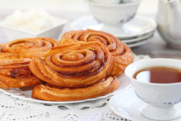 Baked sweet cinnamon rolls with cup of tea