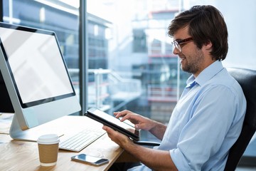 Businessman using digital tablet at desk