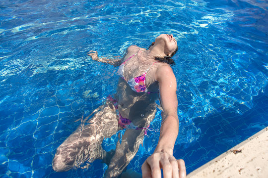 Sexy woman in bikini swimming in the  pool