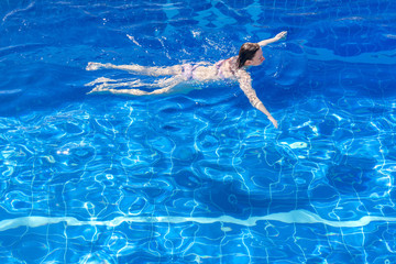 Woman in a bikini floating in swimming pool