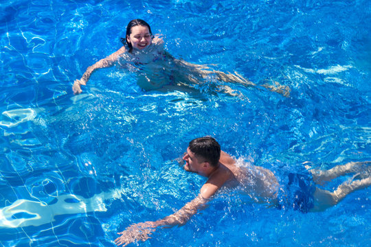 Couple man and woman swimming in the pool