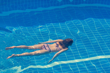 Woman in a bikini  swimming in the pool