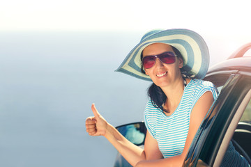 Relaxed happy woman on summer road trip travel vacation showing thumbs up