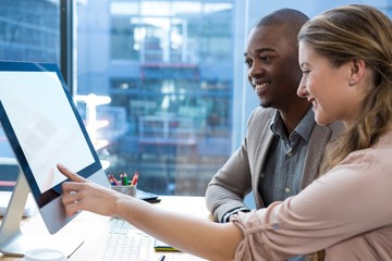 Graphic designer working at desk with colleague