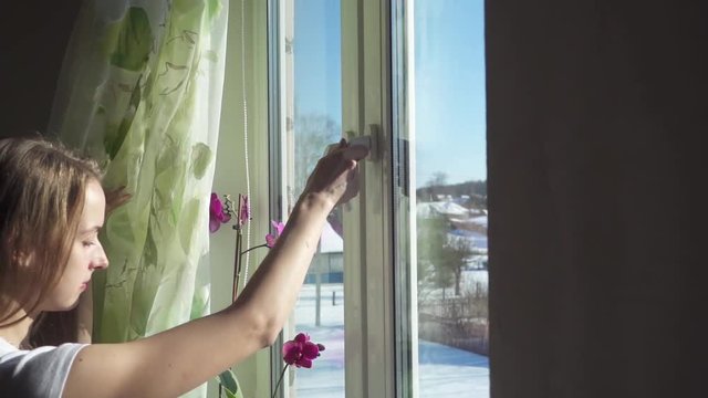 Woman is opening window and breathing fresh frosty air in snowy mountains, slow motion hd video
