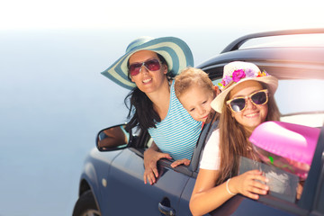 Mother with two kids travel by car on sea vacation selective focus