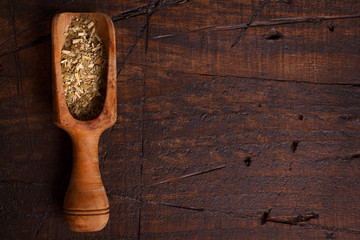 Mate with scoop on wooden background
