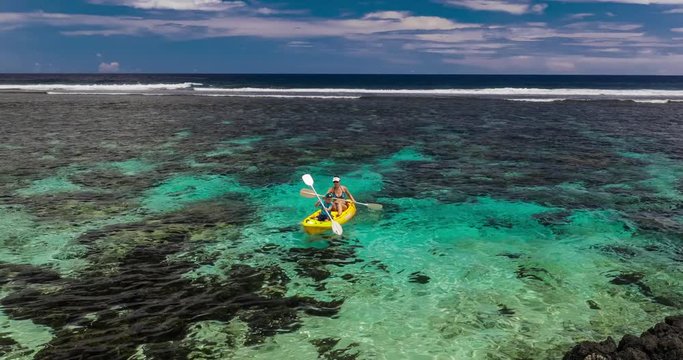 Female and little boy paddling canoe on a tropical lagoon