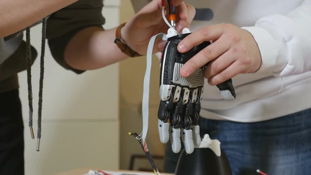 Engineers work at lab making robotic bionic arm. Electronic bionic prosthetic arm. 4K.