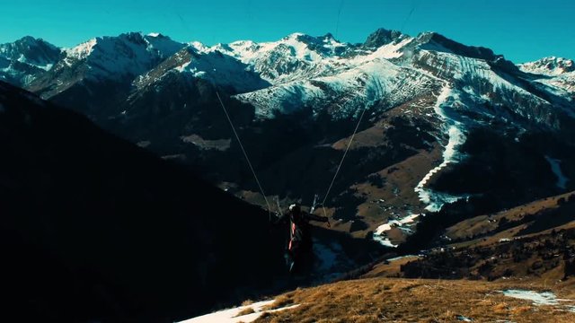 A paragliding soaring along in mountains