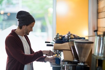 Owner making cup of coffee in espresso machine