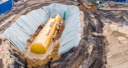 Worker installing a huge fuel tank