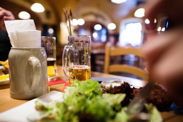 Fototapeta na wymiar Close up of beer mug and meal laid on table.