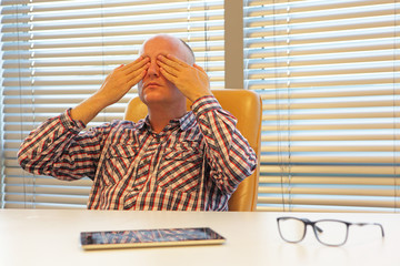 middle age  practicing yoga for eyes in office - break