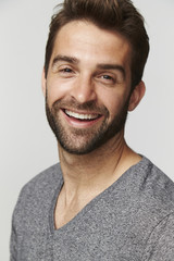 Fototapeta premium Laughing man in grey top, portrait