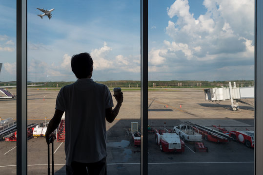 Back side of traveler boy in termainal at airport looking airplane