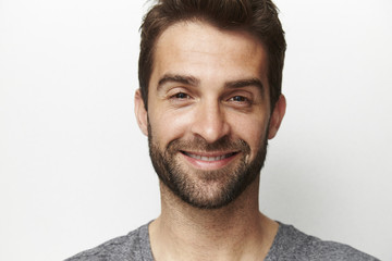 Man with stubble smiling in studio