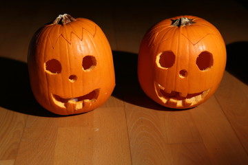 Pair of pumpkins laid on the wooden floor