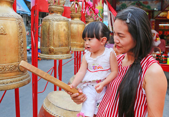 Asian woman and her daugther hit drum and bell in Chinese new year festival