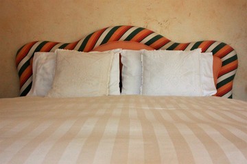 White sheet and colorful striped headboard, italian style