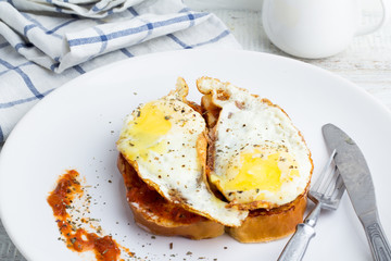 toasts with sauce and fried eggs for breakfast close up