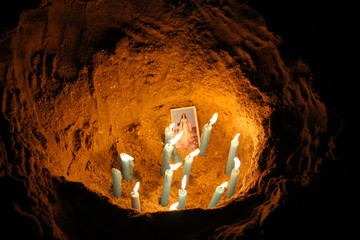 Hole in the sand with candles. Yemanja - religious holiday in Uruguay