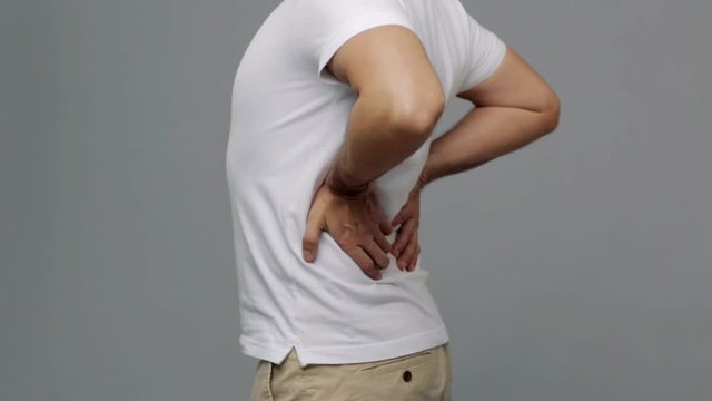 unhappy man suffering from backache at home