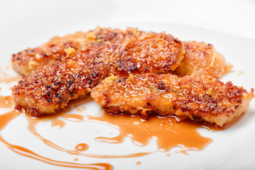 Close up of fried bananas on a white background with caramel. A traditional food in some places in south east asia.