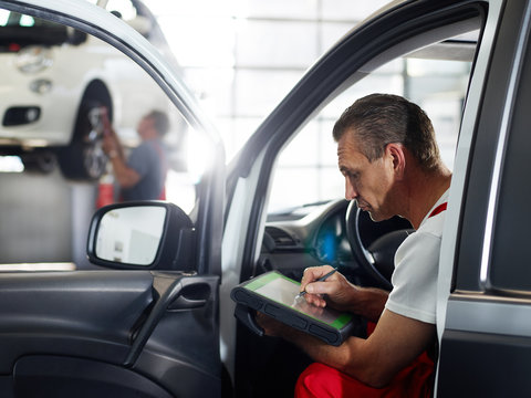 Mechanic checks the engine of a car