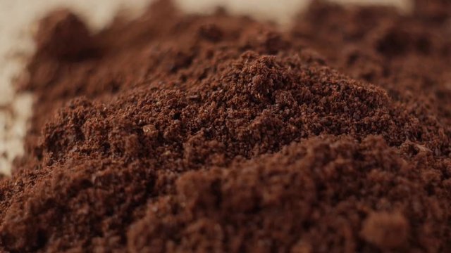 Fine ground coffee powder pile close-up shallow DOF. The slow motion rotation.