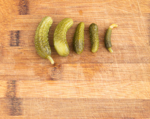 Homemade Pickled Gherkins or Cucumbers Over Rustic Wooden Background