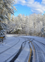 Obraz premium Curve on a Snowy, Icy Road with Tire Tracks