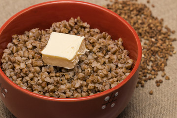 Buckwheat in a red bowl. Healthy food. Buckwheat porridge and bu